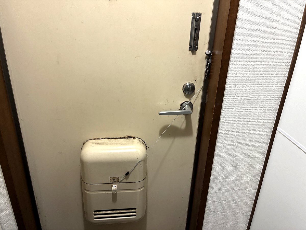 OKIPPAの専用ロックのワイヤーを玄関ドアの内側から固定した様子
