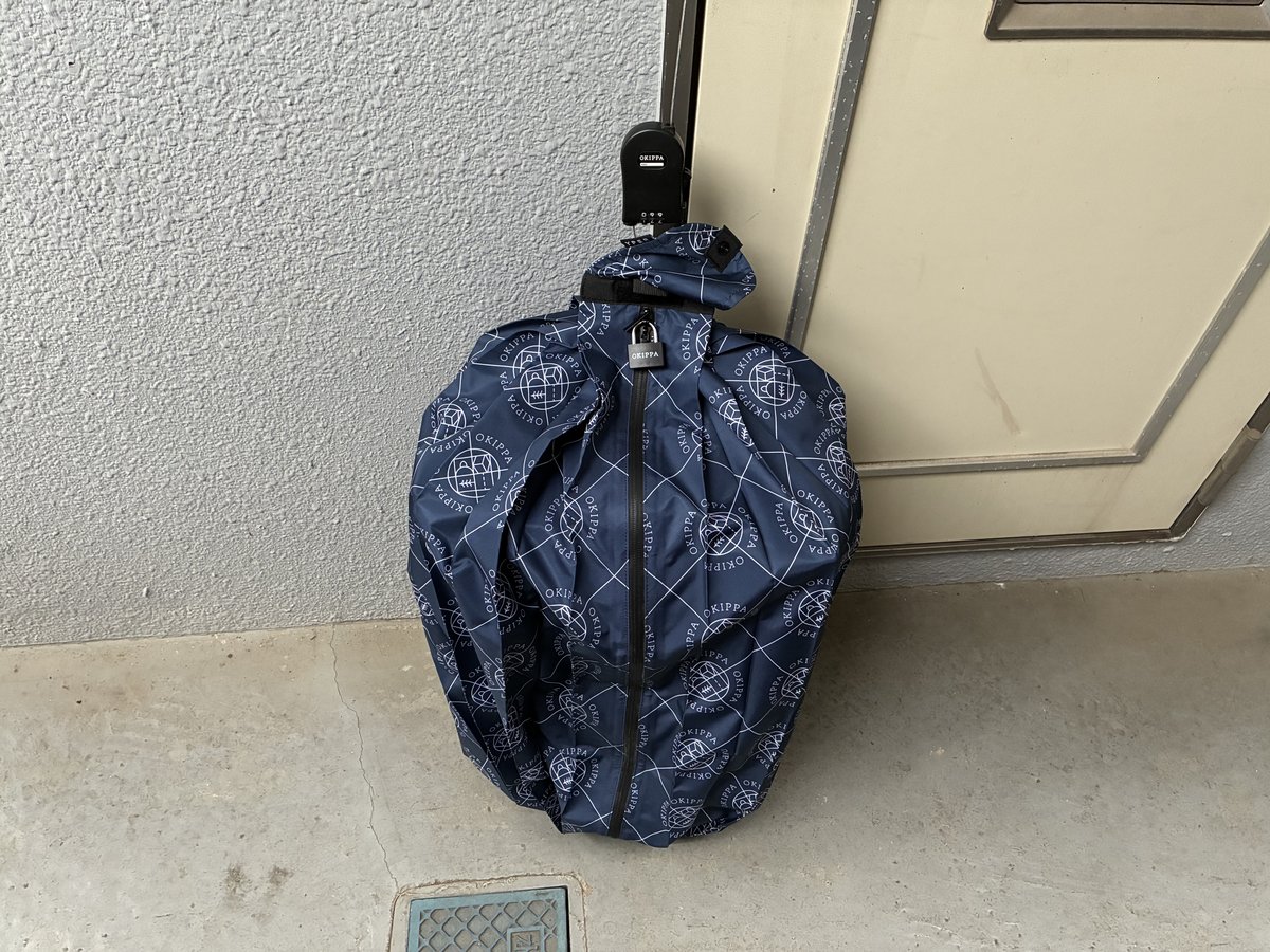 荷物を入れて展開しダイヤルロックで施錠した置き配バッグOKIPPA